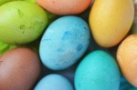 Eggs dyed in different soft colors: blue, green, orange, brown and yellow.