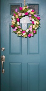 Wreath of different colored tulips hung on door.