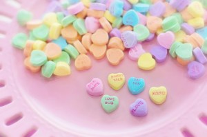 Conversation hearts candies with words and phrases printed on them like Love, Soul Mate, Sweet Talk, XOXO, Love Bug and Say Yes.