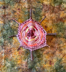 Yellow, red and orange yarn and raffia woven around eight spokes of sticks.