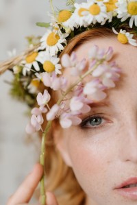 A woman wearing a crown of daisies.