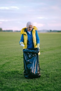 A woman picking up trash.